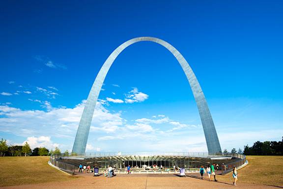A large arch structure with people walking around it.
