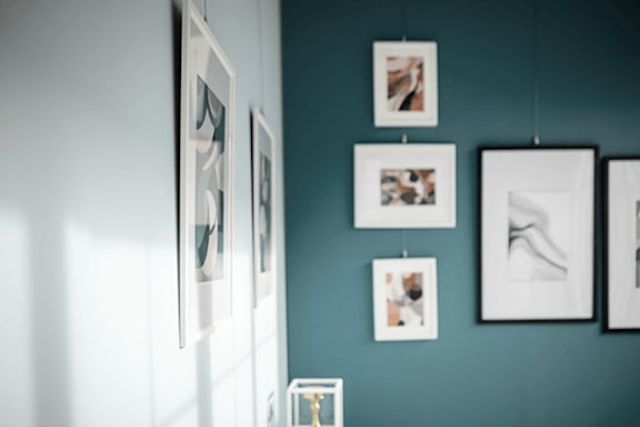 A wall with a collection of framed pictures hanging on it.