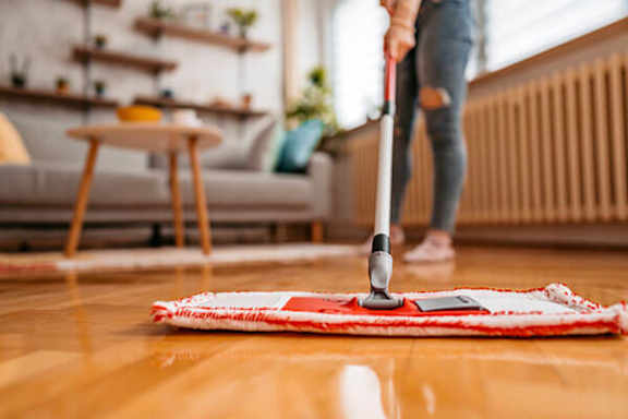 A woman is vacuuming a rug in a living room.