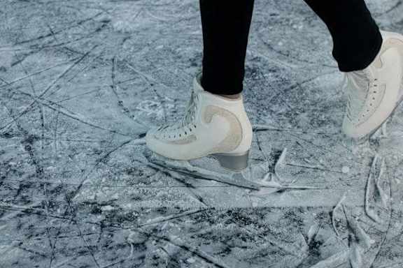 a person with white shoes standing on ice