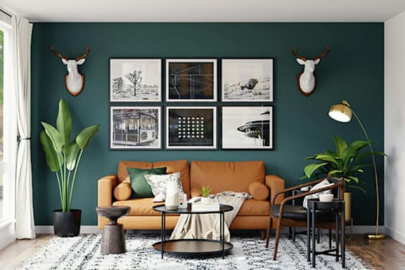 A living room with a green wall and a brown couch.