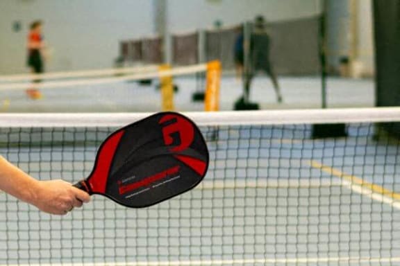 a person holding a tennis racket on a court