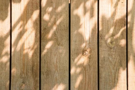 a wooden fence with shadows on it