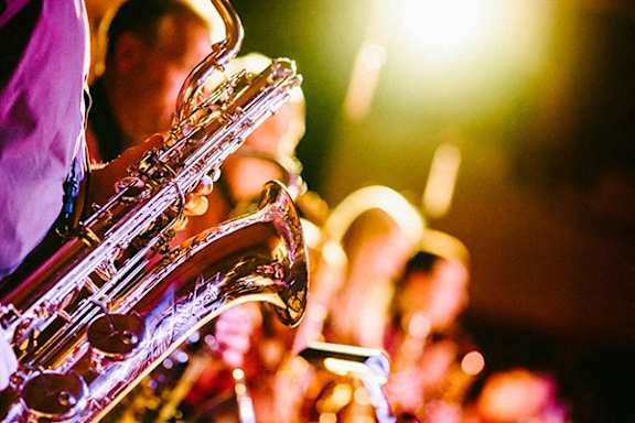 A person playing a saxophone in a concert.