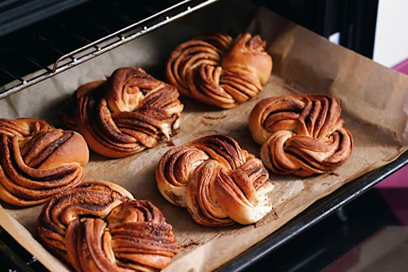 a tray of freshly baked cinnamon buns in an oven