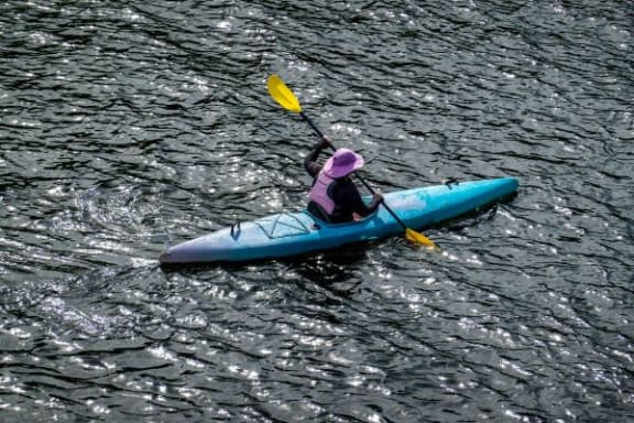 a person in a blue kayak on the water