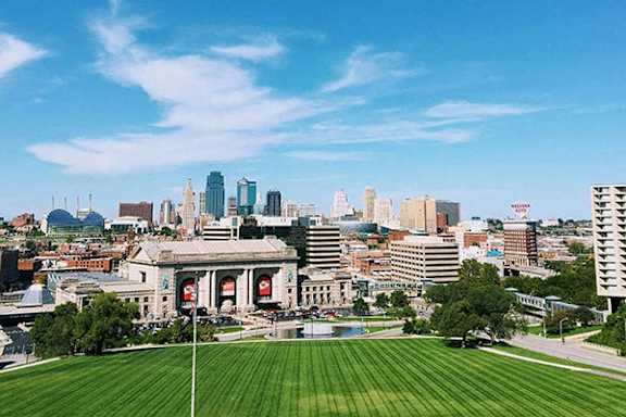 an aerial view of the city with a lawn and the city skyline