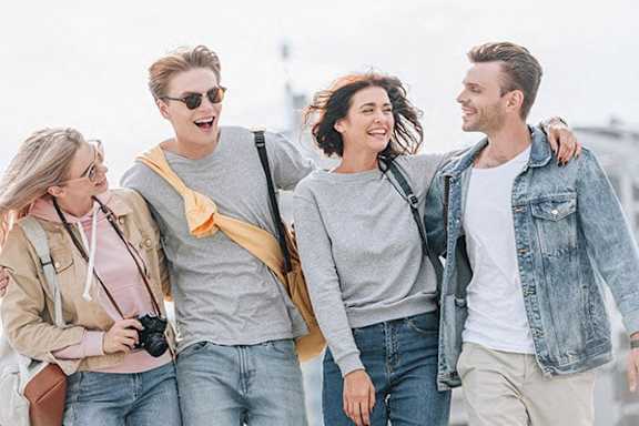 Four friends walking together on a sunny day.