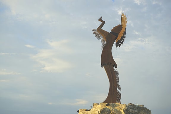 a statue of a woman with wings on a rock