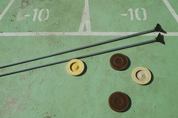 Three yellow and one brown cone on a green surface with a white line.