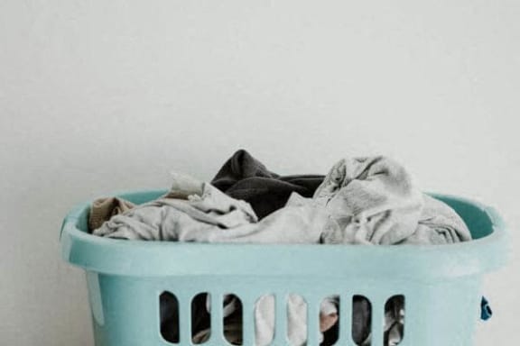 a laundry basket full of clothes on a white