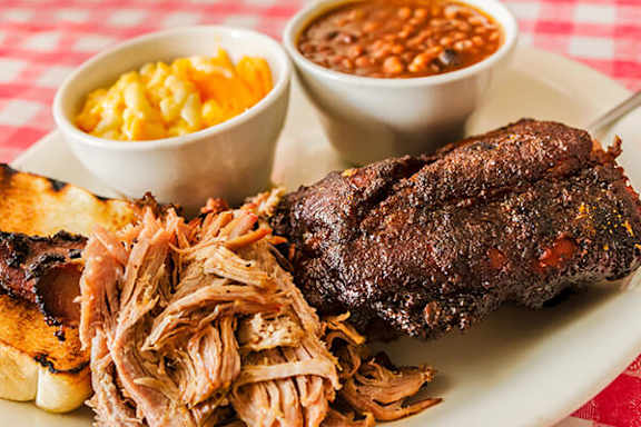 Plate of food with a long piece of meat on it.