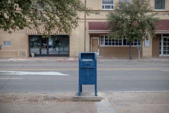 a blue mailbox on the side of a street