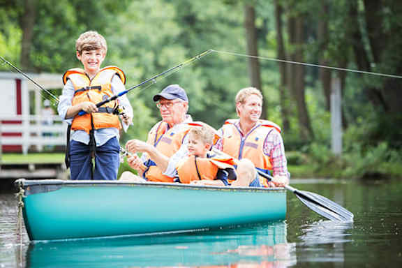A family of four are kayaking on a river.