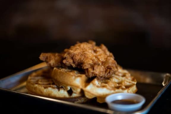 a sandwich with chicken and waffles on a plate
