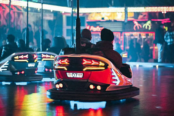 A bumper car with the number 07 519 on it is in the foreground of a bumper car arcade.
