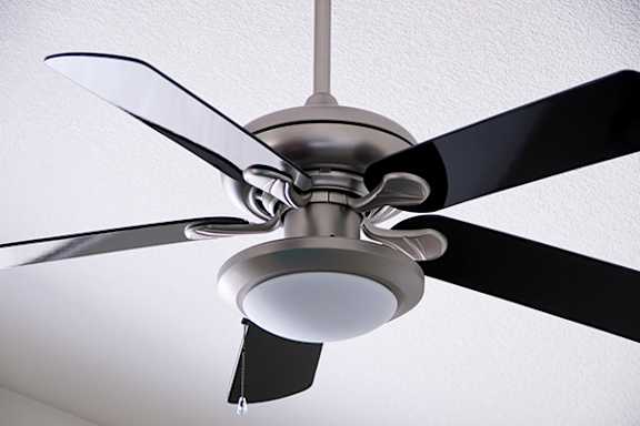 A ceiling fan with a light fixture is mounted on a white ceiling.