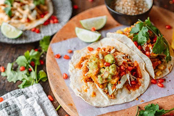 a plate of food with tacos and a bowl of toppings
