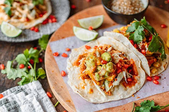 a plate of food with tacos and a bowl of toppings