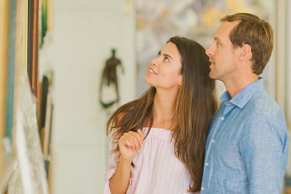 A man and a woman are standing close together, looking up at something out of frame.