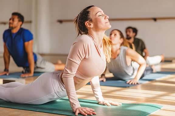 A group of people practicing yoga in a studio.