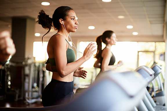 Two women are working out in a gym.