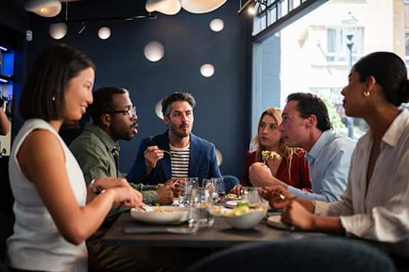 A group of people are sitting around a table eating.