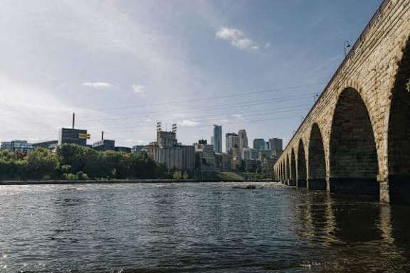 a bridge over a river with a city in the background