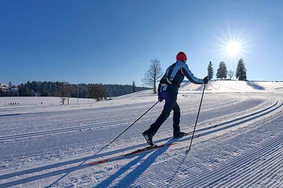 A skier is seen from behind, moving down a snowy slope.