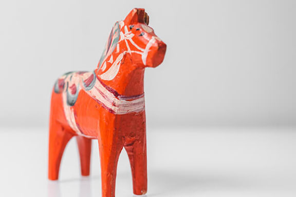a red and white horse figurine on a white surface
