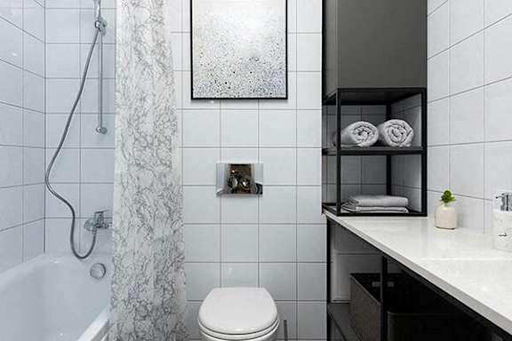 A white toilet sits next to a bathtub in a bathroom.