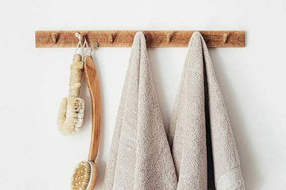 Two towels hanging on a rack with a brush and comb.