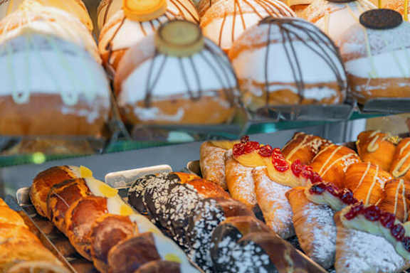 A variety of pastries are displayed in a bakery.