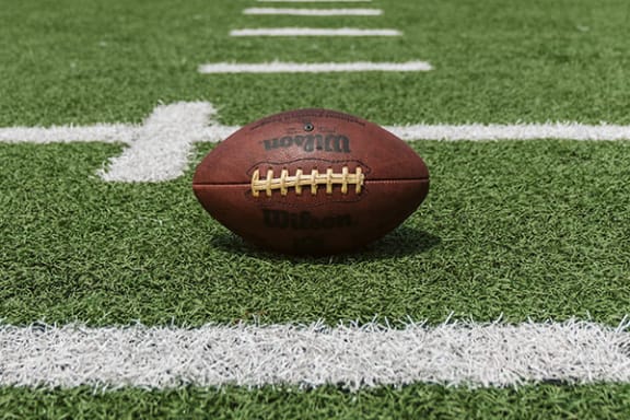 a football sitting on a field on a sunny day