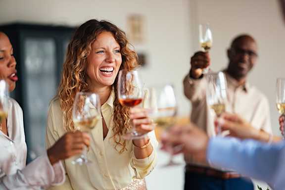 A group of people toasting with wine glasses.