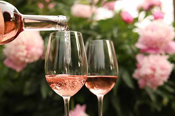 Two glasses of wine being poured into.