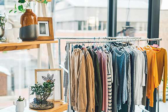 A clothing rack with various shirts hanging on it.