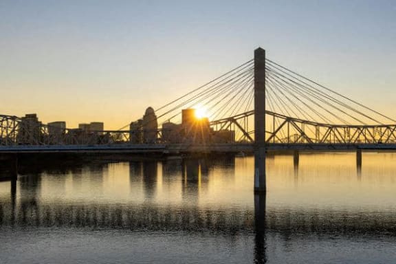 a bridge over a body of water with a sunset