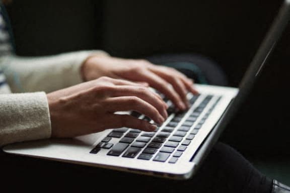 a person typing on a laptop computer
