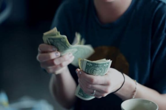 a woman counting money in her hands