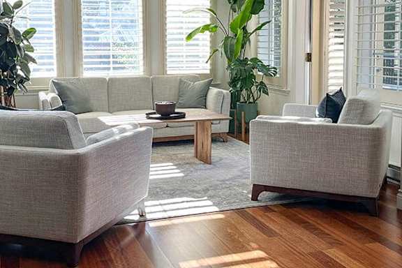 A living room with a grey couch, two armchairs and a coffee table.