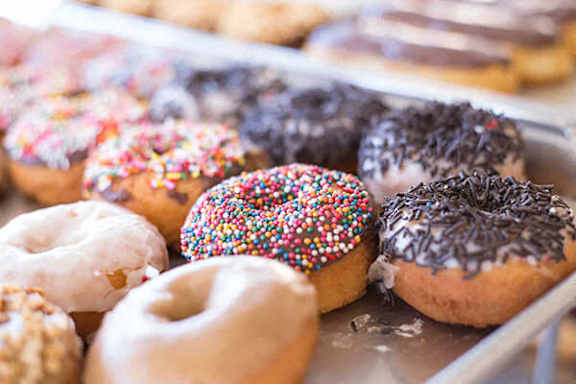 A tray of assorted donuts with various toppings.