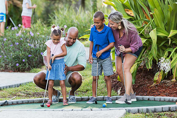 A family playing mini golf together.