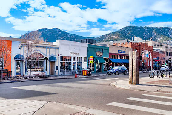 A street view of a town with a mountain in the background.