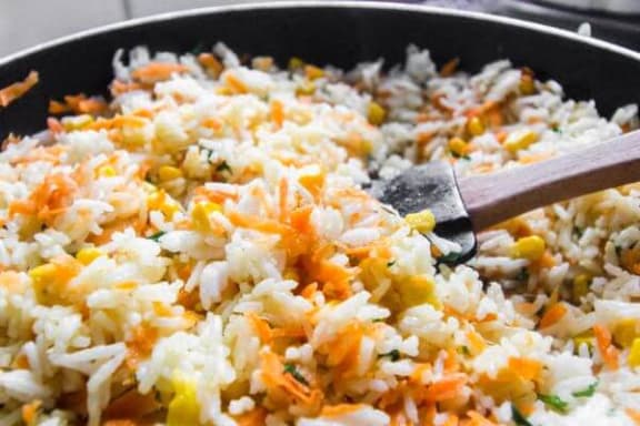 a pan of fried rice with a wooden spoon