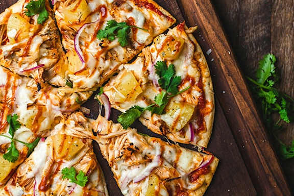 a pizza cut into slices on a wooden cutting board