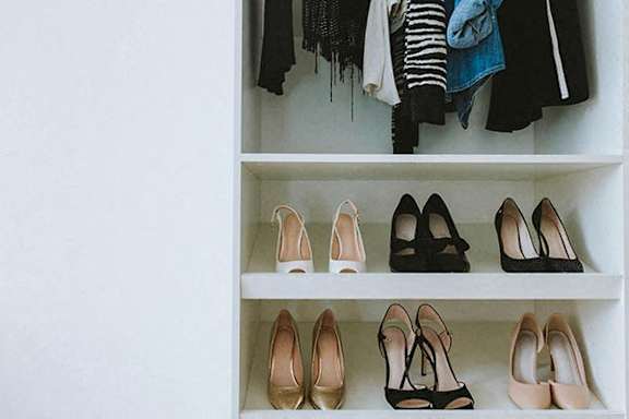 Closet with shoes on the shelf.