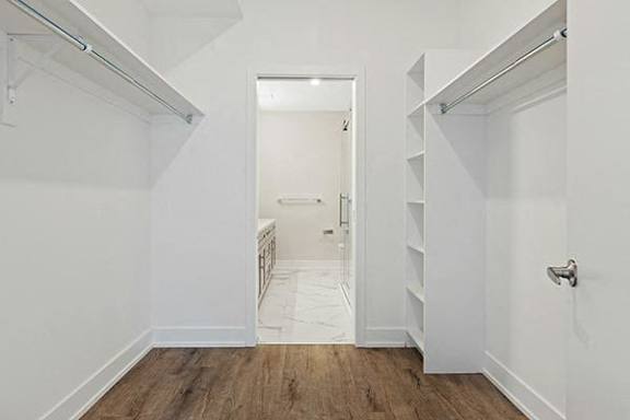 A white hallway with a doorway leading to a bedroom.