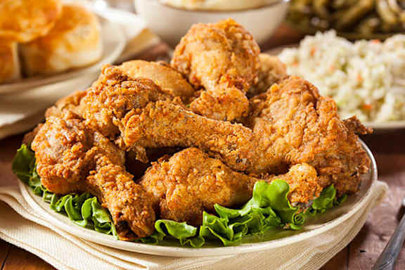 Fried chicken on a plate with lettuce and coleslaw.