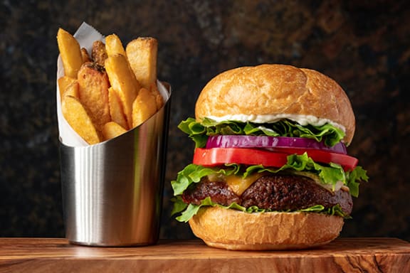 a hamburger and fries sit on a table